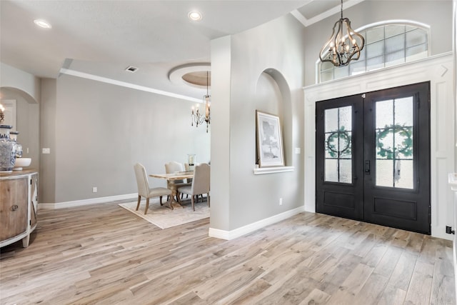 11 Turtle Cove Ct, Kingwood, TX 77346 - foyer featuring a chandelier, french doors, light wood finished floors, crown molding, and baseboards