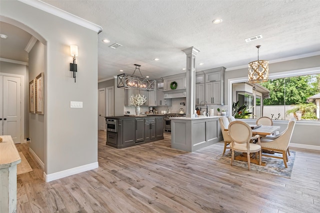 11 Turtle Cove Ct, Kingwood, TX 77346 - dining area with ornamental molding, a chandelier, baseboards, light wood finished floors, and arched walkways