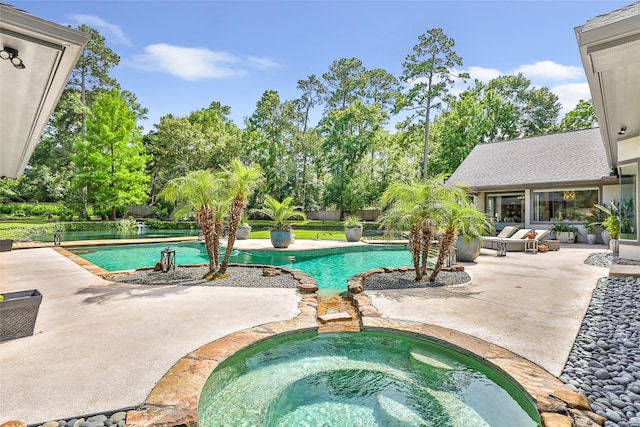 11 Turtle Cove Ct, Kingwood, TX 77346 - swimming pool with an in-ground hot tub, a patio area, and view of wooded area