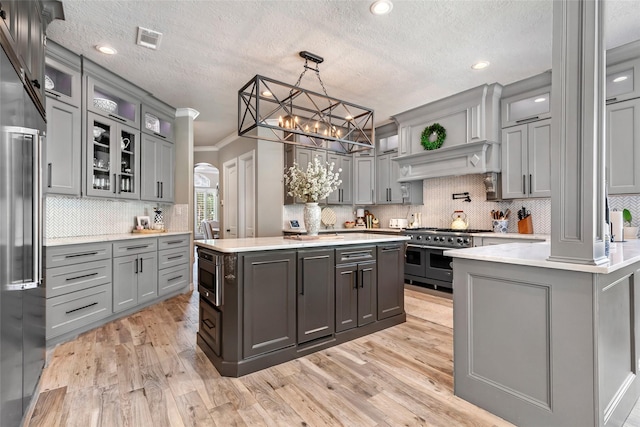 11 Turtle Cove Ct, Kingwood, TX 77346 - kitchen with high end appliances, gray cabinetry, light countertops, a textured ceiling, and ornamental molding