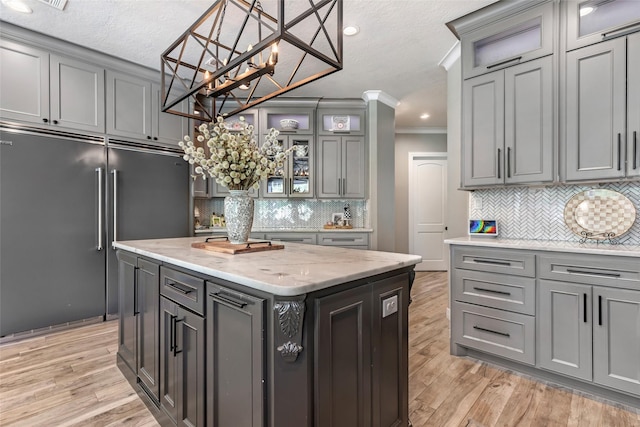 11 Turtle Cove Ct, Kingwood, TX 77346 - kitchen with built in fridge, gray cabinetry, ornamental molding, decorative backsplash, and a textured ceiling