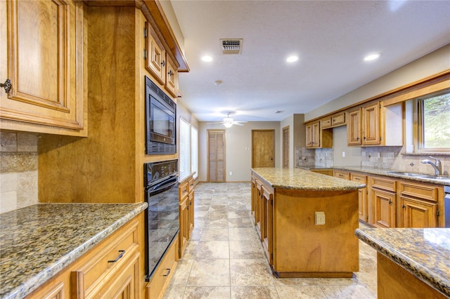 538 Everington Dr, Katy, TX 77450 - kitchen with black appliances, a sink, light stone counters, backsplash, and a ceiling fan