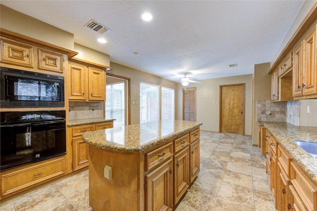538 Everington Dr, Katy, TX 77450 - kitchen with black appliances, tasteful backsplash, a kitchen island, light stone countertops, and recessed lighting