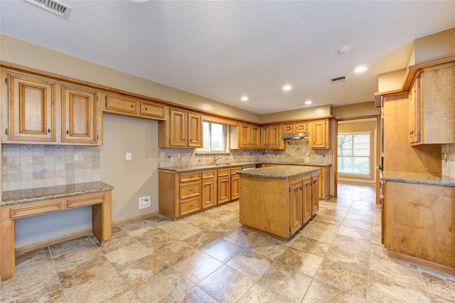 538 Everington Dr, Katy, TX 77450 - kitchen with a center island, backsplash, healthy amount of natural light, light stone countertops, and recessed lighting