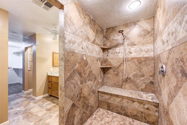 538 Everington Dr, Katy, TX 77450 - bathroom with a tile shower, a ceiling fan, vanity, a textured ceiling, and baseboards