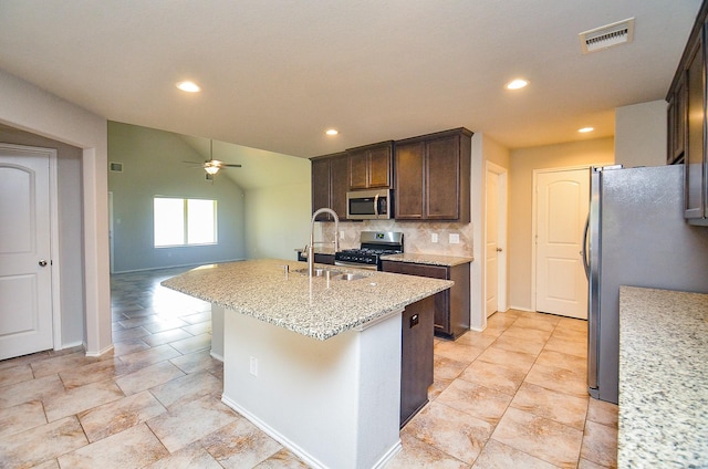 23807 Ancona Ct, Katy, TX 77493 - kitchen with appliances with stainless steel finishes, ceiling fan, recessed lighting, dark brown cabinetry, and a center island with sink