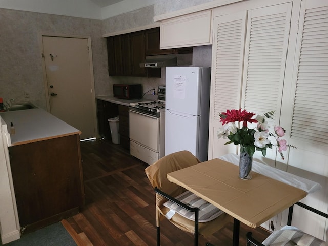 2013 Deats Rd, Dickinson, TX 77539 - kitchen featuring white appliances, under cabinet range hood, dark wood-style floors, a sink, and wallpapered walls