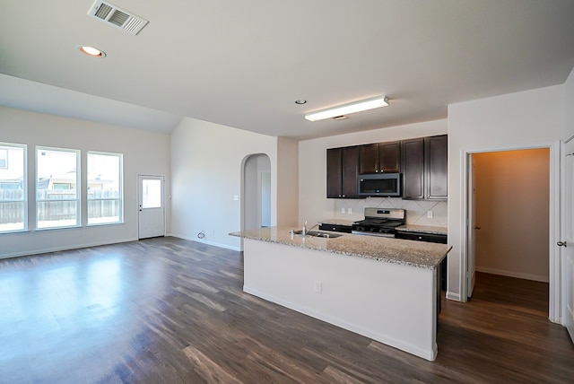 10314 White Fir Villa Ave, Houston, TX 77044 - kitchen featuring appliances with stainless steel finishes, arched walkways, dark wood finished floors, a sink, and dark brown cabinetry