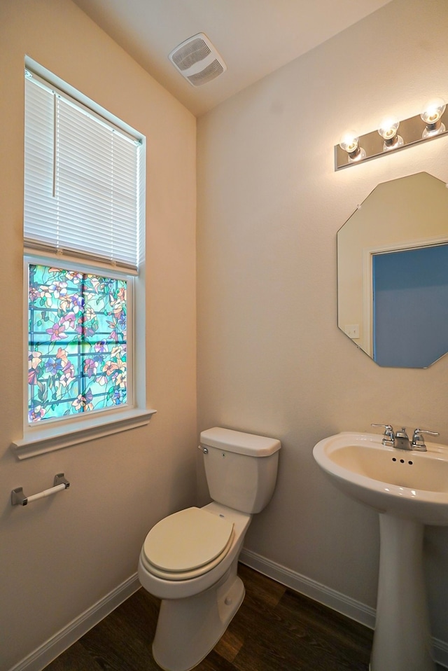 10314 White Fir Villa Ave, Houston, TX 77044 - half bathroom with wood finished floors, toilet, baseboards, and a sink