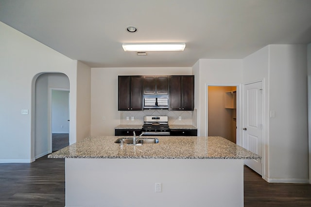10314 White Fir Villa Ave, Houston, TX 77044 - kitchen featuring a sink, stainless steel gas stove, arched walkways, dark wood-style flooring, and dark brown cabinetry