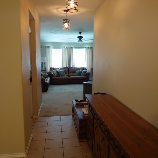 13564 Miller Ln, Willis, TX 77318 - hallway with light carpet, light tile patterned flooring, and baseboards