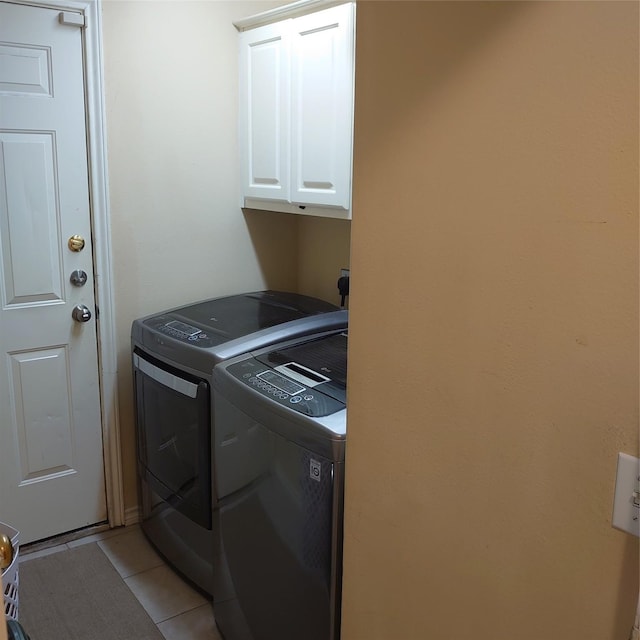 13564 Miller Ln, Willis, TX 77318 - laundry area with cabinet space, light tile patterned floors, and washing machine and dryer