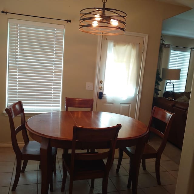 13564 Miller Ln, Willis, TX 77318 - dining area with light tile patterned floors and a chandelier