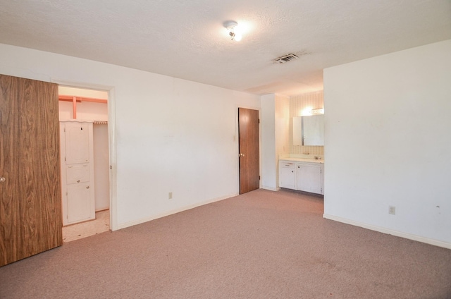 346 9th St, Hempstead, TX 77445 - unfurnished bedroom with light colored carpet, ensuite bath, and baseboards