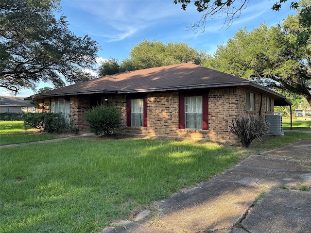 346 9th St, Hempstead, TX 77445 - ranch-style home featuring brick siding, central AC unit, a front lawn, and a shingled roof