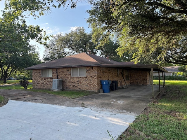 346 9th St, Hempstead, TX 77445 - view of property exterior featuring concrete driveway, cooling unit, brick siding, and an attached carport
