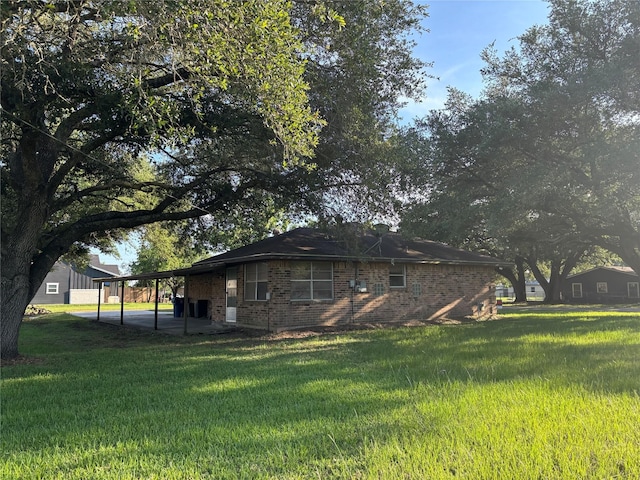 346 9th St, Hempstead, TX 77445 - view of side of property featuring brick siding, a yard, and a carport