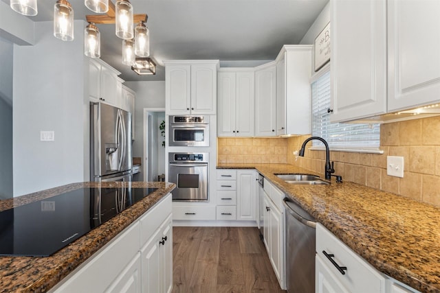 1022 Long Reach Dr, Tiki Island, TX 77554 - kitchen with stainless steel appliances, a sink, dark stone counters, white cabinetry, and tasteful backsplash