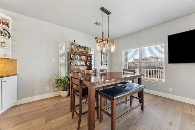 1022 Long Reach Dr, Tiki Island, TX 77554 - dining space featuring light wood-style flooring, baseboards, and a chandelier