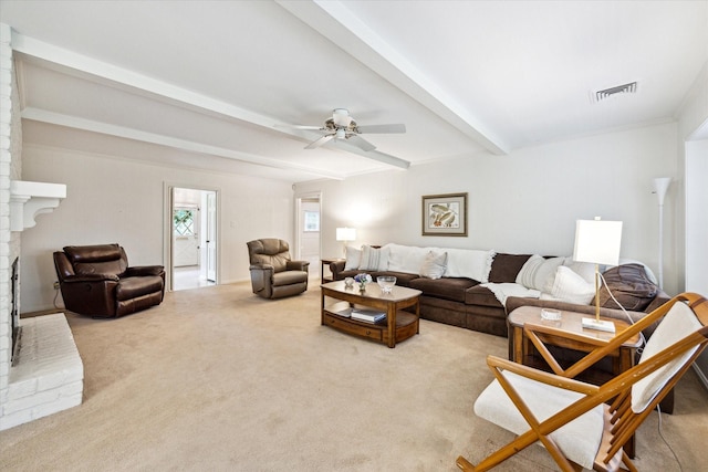 carpeted living area featuring beamed ceiling, a ceiling fan, and decorative columns