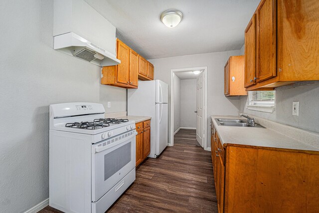 7433 Yoe St, Houston, TX 77016 - kitchen featuring white appliances, a sink, custom exhaust hood, baseboards, and dark wood-style floors