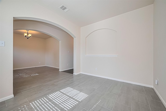 1526 Claremont Garden Cir, Houston, TX 77047 - spare room featuring arched walkways, a chandelier, wood tiled floors, and baseboards