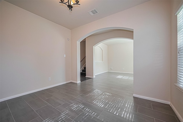 1526 Claremont Garden Cir, Houston, TX 77047 - unfurnished room featuring stairs, baseboards, arched walkways, and tile patterned floors