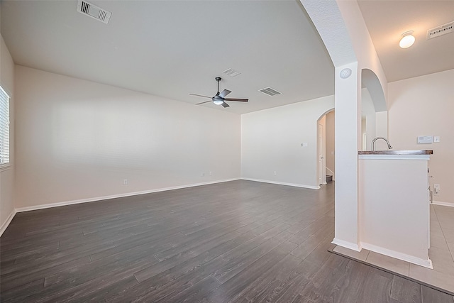 1526 Claremont Garden Cir, Houston, TX 77047 - spare room featuring ceiling fan, arched walkways, dark wood-type flooring, and baseboards
