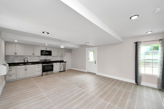 5903 Belneath St, Houston, TX 77033 - kitchen featuring appliances with stainless steel finishes, baseboards, dark countertops, backsplash, and recessed lighting