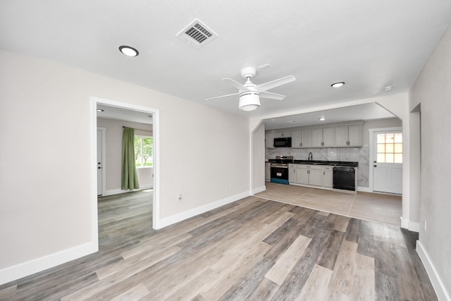 5903 Belneath St, Houston, TX 77033 - unfurnished living room with a ceiling fan, light wood-style flooring, baseboards, and recessed lighting