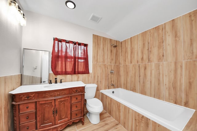 5903 Belneath St, Houston, TX 77033 - full bath with toilet, wood finished floors, vanity, tub / shower combination, and vaulted ceiling