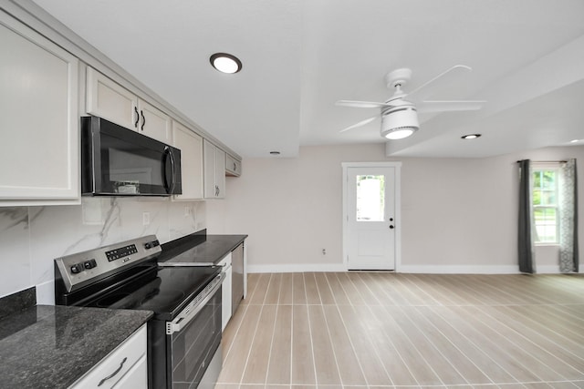 5903 Belneath St, Houston, TX 77033 - kitchen with black microwave, stainless steel electric range oven, a ceiling fan, baseboards, and dark stone counters