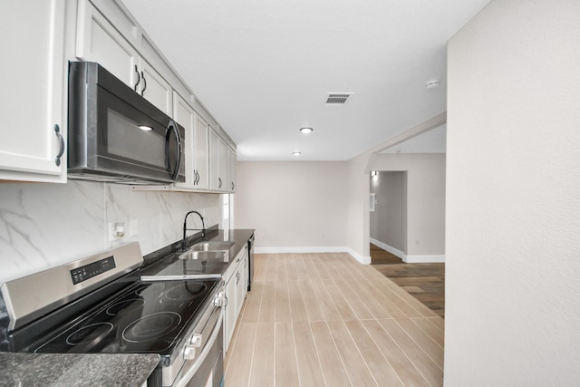 5903 Belneath St, Houston, TX 77033 - kitchen featuring electric stove, black microwave, a sink, decorative backsplash, and dark countertops