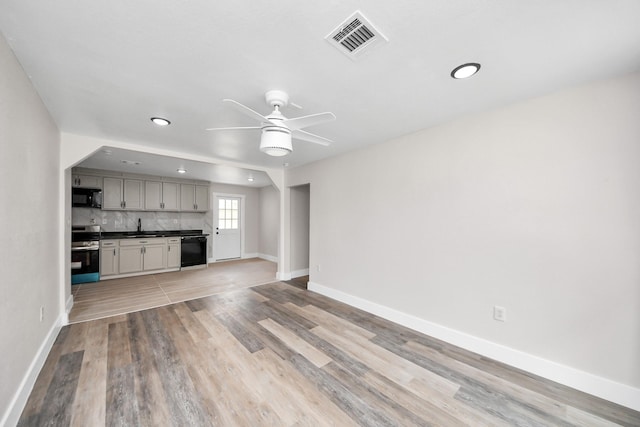 5903 Belneath St, Houston, TX 77033 - unfurnished living room featuring baseboards, a sink, ceiling fan, recessed lighting, and light wood-style flooring