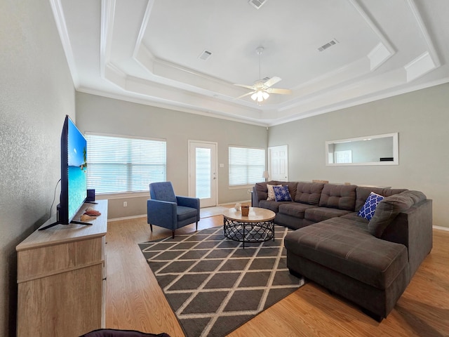 3229 Castle Dr, Crystal Beach, TX 77650 - living area featuring wood finished floors, a tray ceiling, a ceiling fan, ornamental molding, and baseboards