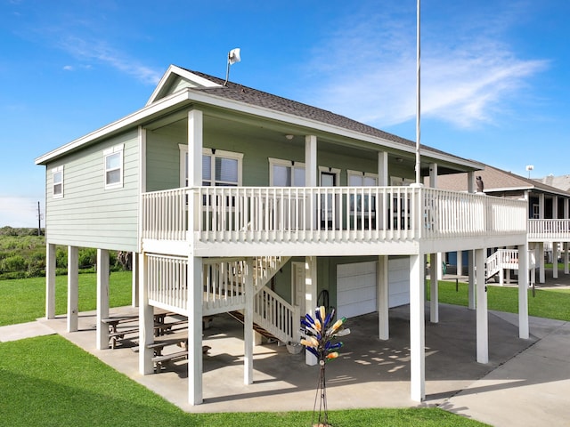 3229 Castle Dr, Crystal Beach, TX 77650 - rear view of property with an attached garage, covered porch, stairs, and a yard