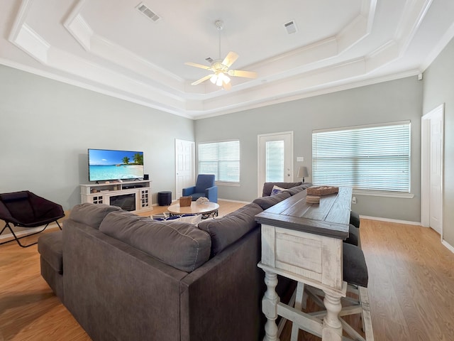 3229 Castle Dr, Crystal Beach, TX 77650 - living area with a tray ceiling, crown molding, ceiling fan, and light wood-style flooring