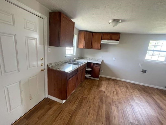 603 Willow St, Baytown, TX 77520 - kitchen featuring a sink, dark wood finished floors, under cabinet range hood, baseboards, and a textured ceiling