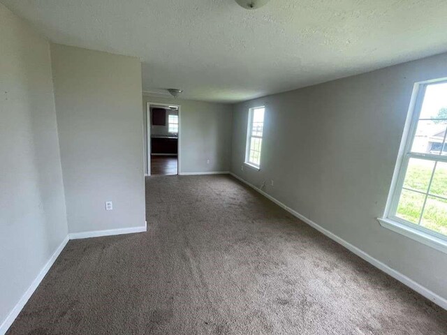 603 Willow St, Baytown, TX 77520 - carpeted empty room with baseboards and a textured ceiling