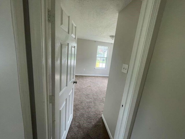 603 Willow St, Baytown, TX 77520 - hall featuring carpet floors, a textured ceiling, and baseboards