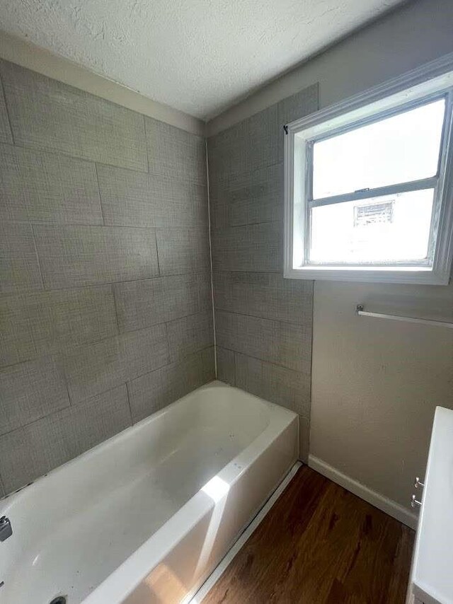 603 Willow St, Baytown, TX 77520 - full bath featuring wood finished floors, baseboards, and a textured ceiling