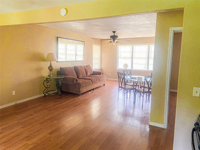340 Warner St, Bridge City, TX 77611 - living room with wood finished floors, baseboards, ceiling fan, and a textured ceiling