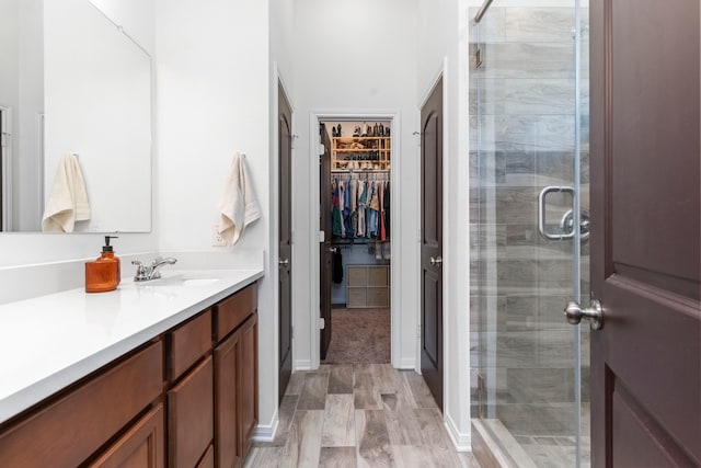3221 Climbing Gardens Ct, Conroe, TX 77301 - full bath featuring a shower stall, wood finished floors, a walk in closet, and vanity