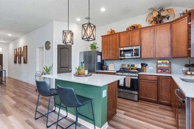 3221 Climbing Gardens Ct, Conroe, TX 77301 - kitchen with appliances with stainless steel finishes, light wood-style flooring, a kitchen bar, backsplash, and recessed lighting
