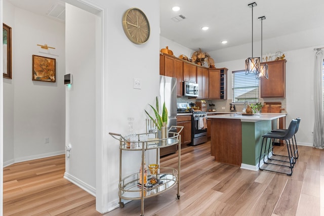 3221 Climbing Gardens Ct, Conroe, TX 77301 - kitchen featuring appliances with stainless steel finishes, light wood-type flooring, decorative backsplash, brown cabinetry, and a kitchen breakfast bar