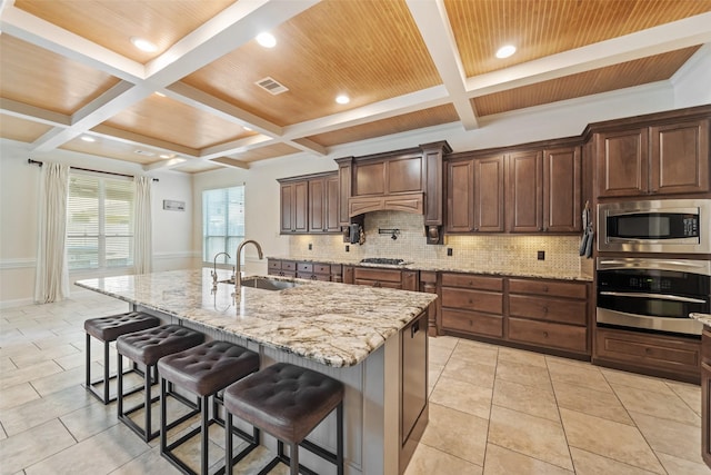 17726 Rough River Ct, Humble, TX 77346 - kitchen with appliances with stainless steel finishes, coffered ceiling, a sink, backsplash, and a kitchen breakfast bar