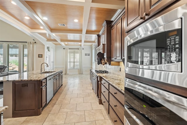 17726 Rough River Ct, Humble, TX 77346 - kitchen with a sink, stainless steel appliances, coffered ceiling, an island with sink, and light stone counters
