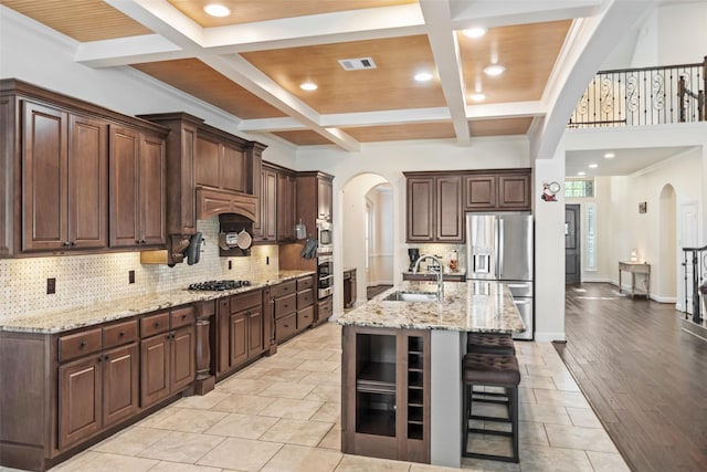 17726 Rough River Ct, Humble, TX 77346 - kitchen with arched walkways, stainless steel appliances, a sink, coffered ceiling, and recessed lighting