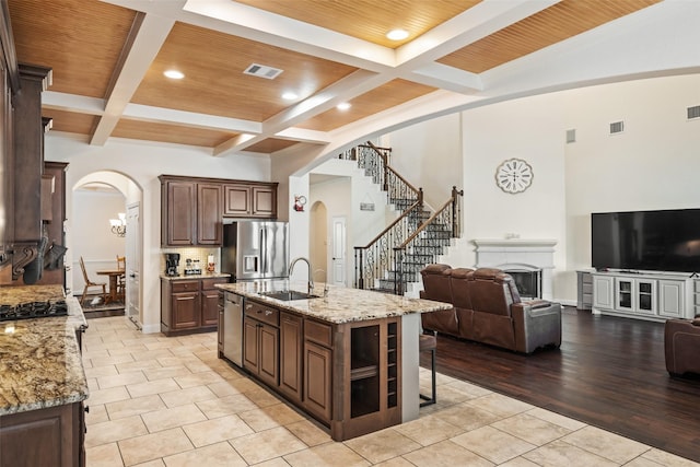 17726 Rough River Ct, Humble, TX 77346 - kitchen featuring appliances with stainless steel finishes, arched walkways, coffered ceiling, a breakfast bar area, and beam ceiling