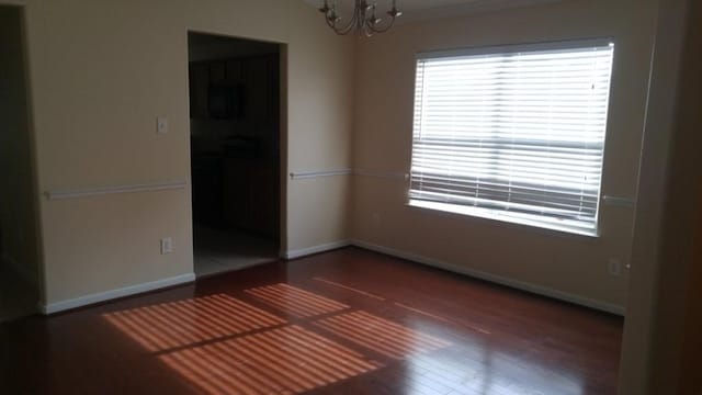 2902 Winslow Forest Ln, Houston, TX 77047 - empty room featuring a chandelier, wood finished floors, and baseboards